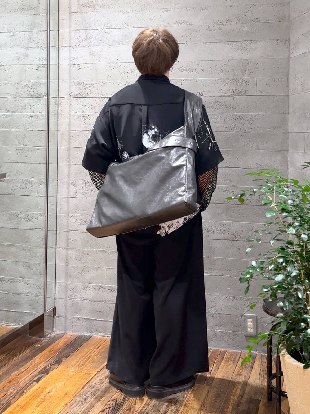 ブラック系のサンダル、グレー系のショルダーバッグ、ブラック系のスラックスを着用したメンズの春コーディネートの3枚目の写真