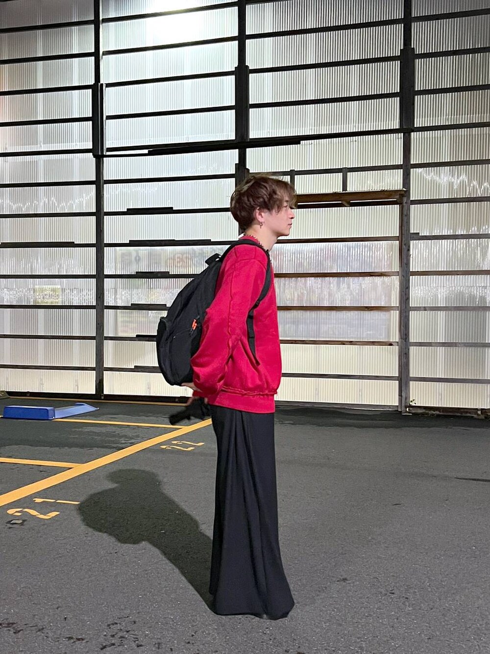 ブラック系のその他パンツ、レッド系のスウェット、シルバー系のピアス（片耳用）を着用したメンズの秋コーディネートの3枚目の写真