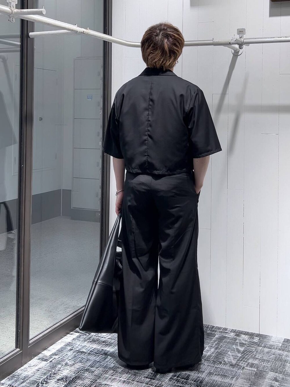 ブラック系のドレスシューズ、ブラック系のトートバッグ、ブラック系のTシャツ/カットソーを着用したメンズの春コーディネートの4枚目の写真