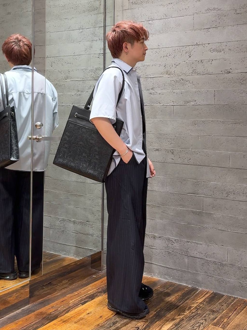 ブラック系のサンダル、ブラック系のTシャツ/カットソー、ブルー系のスラックスを着用したメンズの夏コーディネートの2枚目の写真