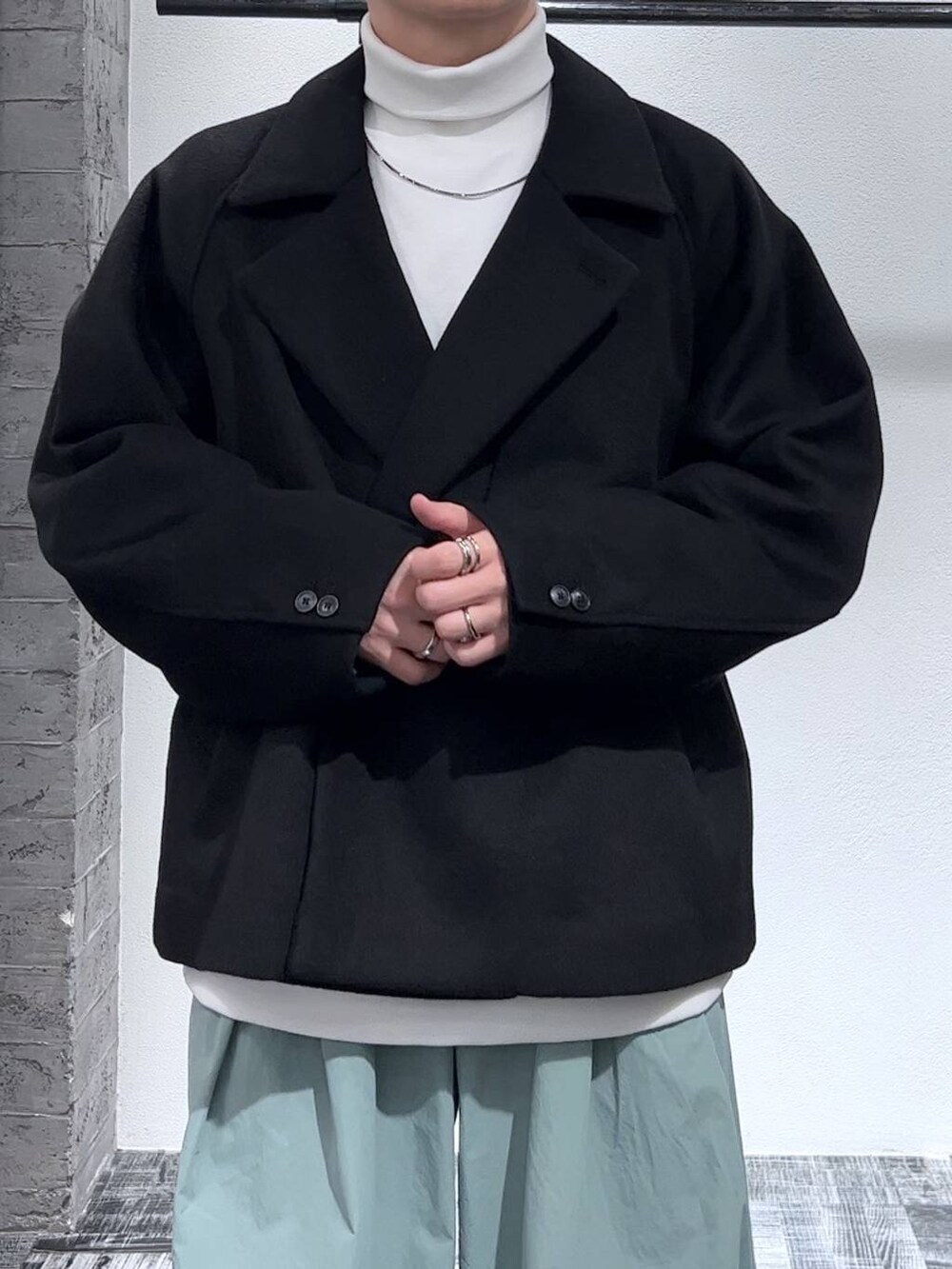 ブラック系のブルゾン、ブラック系のブーツ、ホワイト系のスウェットを着用したメンズの秋コーディネートの5枚目の写真