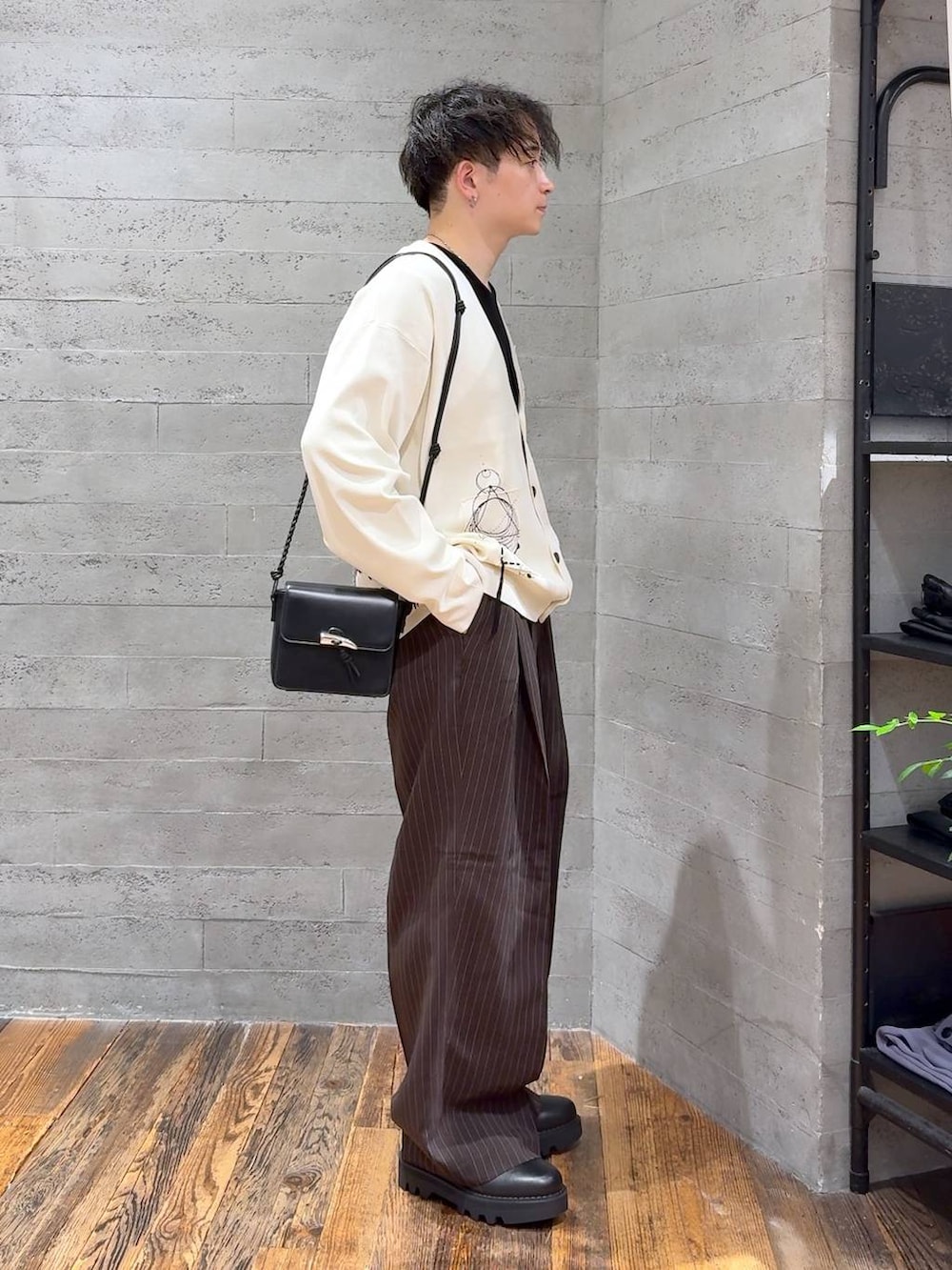 ブラック系のドレスシューズ、ブラック系のショルダーバッグ、ブラウン系のスラックスを着用したメンズの夏コーディネートの2枚目の写真