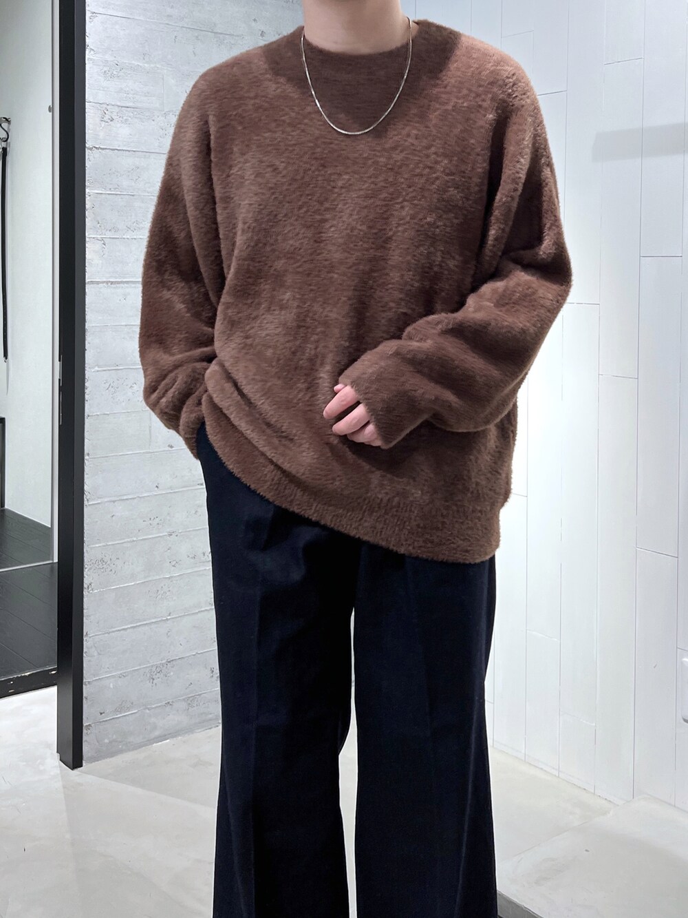 ブラウン系のニット/セーター、ブルー系のデニムパンツ、ブラック系のブーツを着用したメンズの秋コーディネートの4枚目の写真