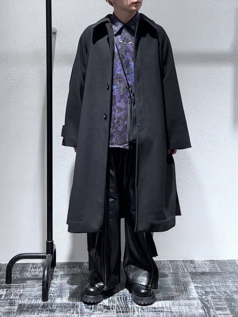 ブラック系のステンカラーコート、ブラック系のショルダーバッグ、ブラック系のブーツを着用したメンズの秋コーディネートの2枚目の写真