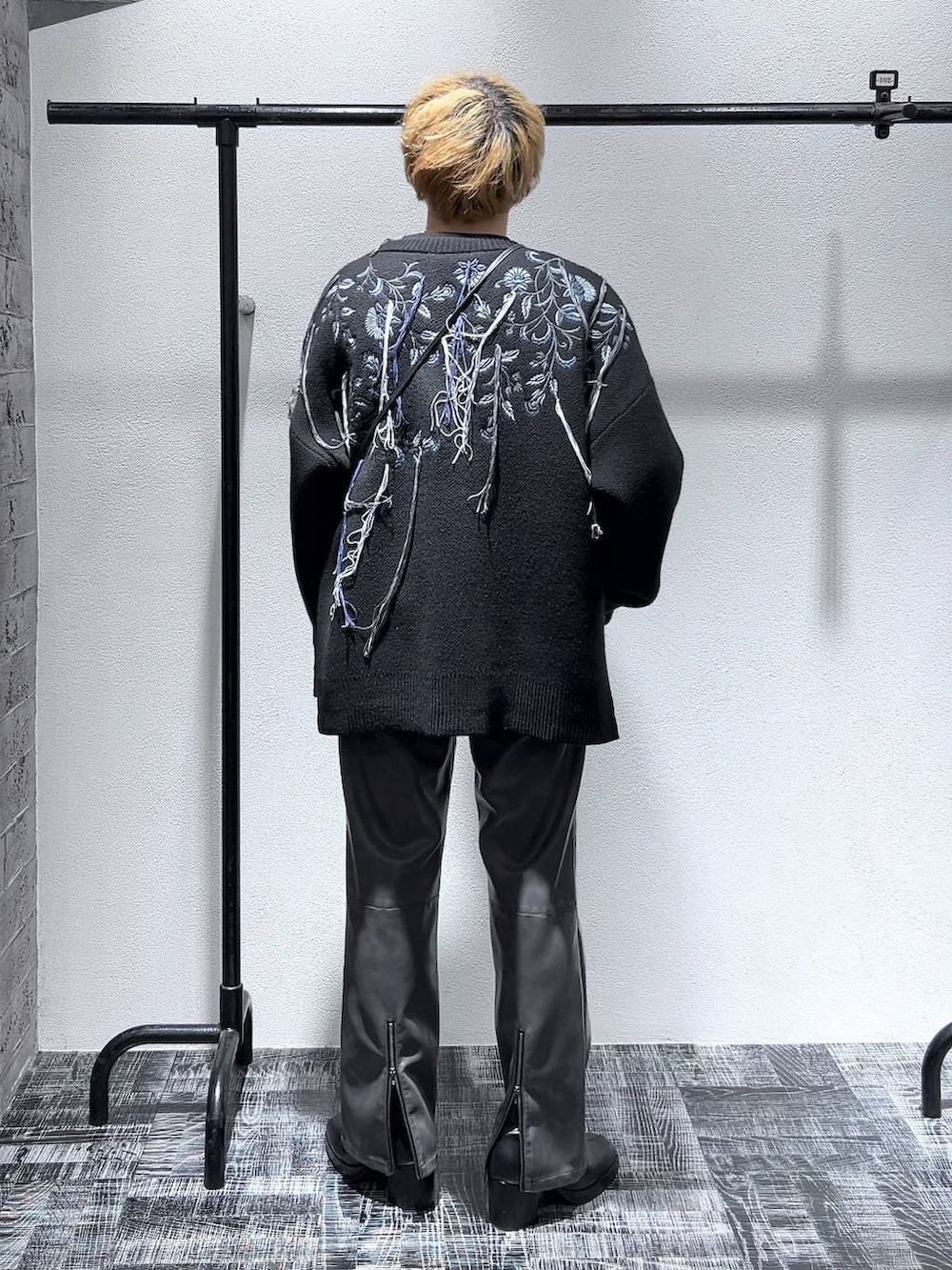 ブラック系のカーディガン/ボレロ、ブラック系のブーツ、ブラック系のショルダーバッグを着用したメンズの冬コーディネートの3枚目の写真