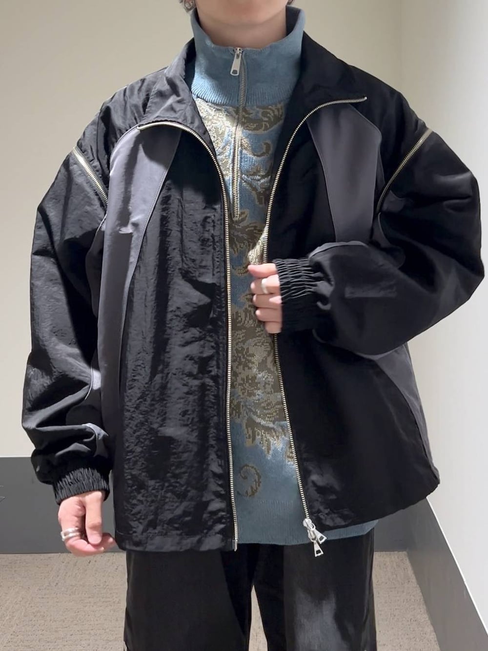 ブラック系のドレスシューズ、ブラック系のデニムパンツ、ブルー系のニット/セーターを着用したメンズの冬コーディネートの5枚目の写真