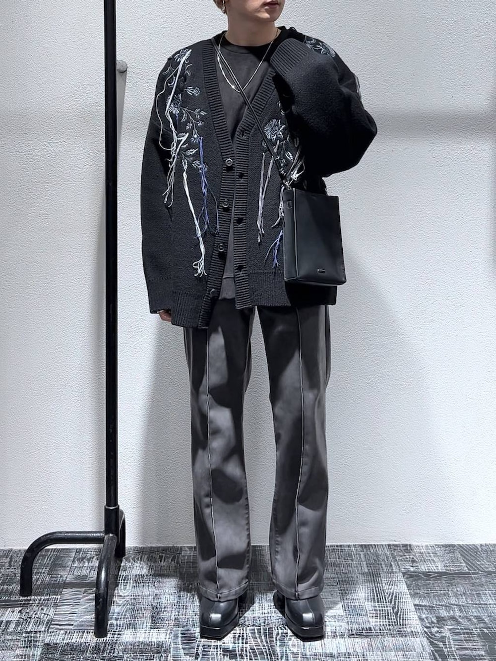 ブラック系のカーディガン/ボレロ、ブラック系のブーツ、ブラック系のショルダーバッグを着用したメンズの冬コーディネートの4枚目の写真