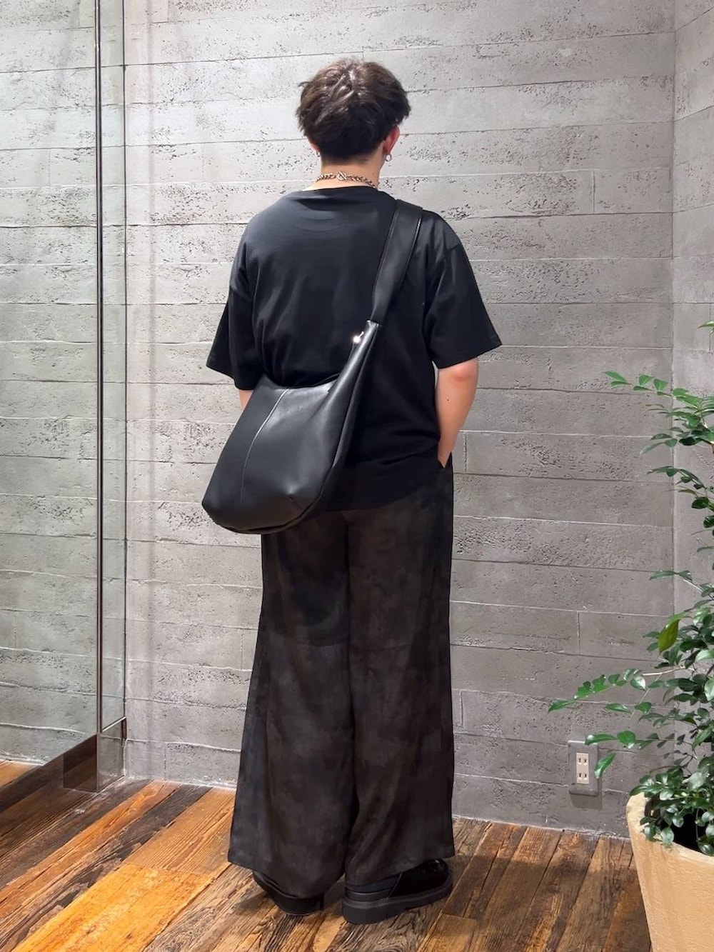 ブラック系のサンダル、グレー系のスラックス、ブラック系のTシャツ/カットソーを着用したメンズの夏コーディネートの3枚目の写真