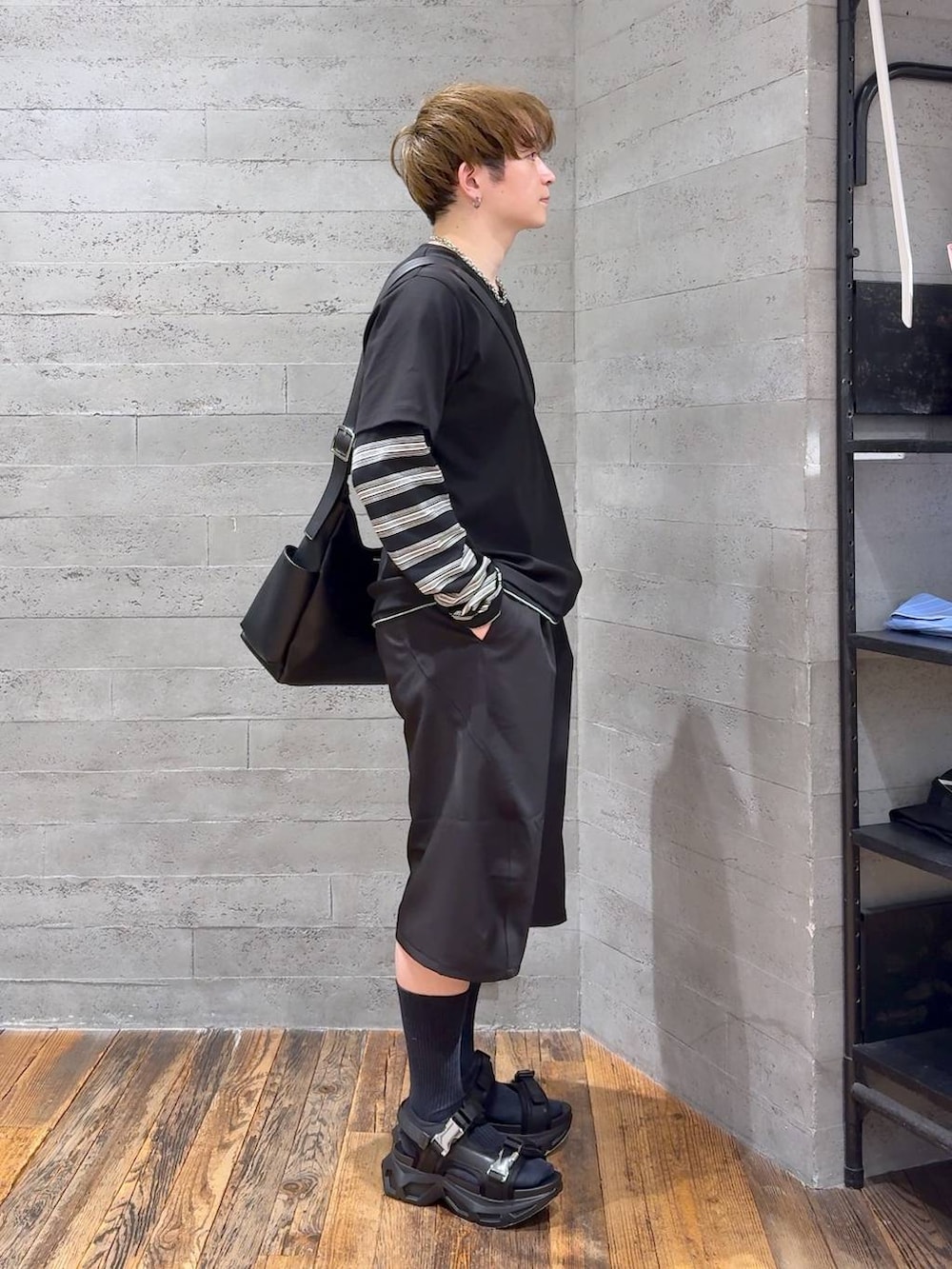 ブラック系のサンダル、ブラック系のショルダーバッグ、ブラック系のスラックスを着用したメンズの春コーディネートの2枚目の写真