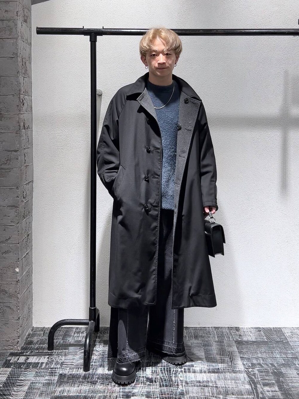 ブラック系のデニムパンツ、ブラック系のショルダーバッグ、グリーン系のニット/セーターを着用したメンズの秋コーディネートの2枚目の写真
