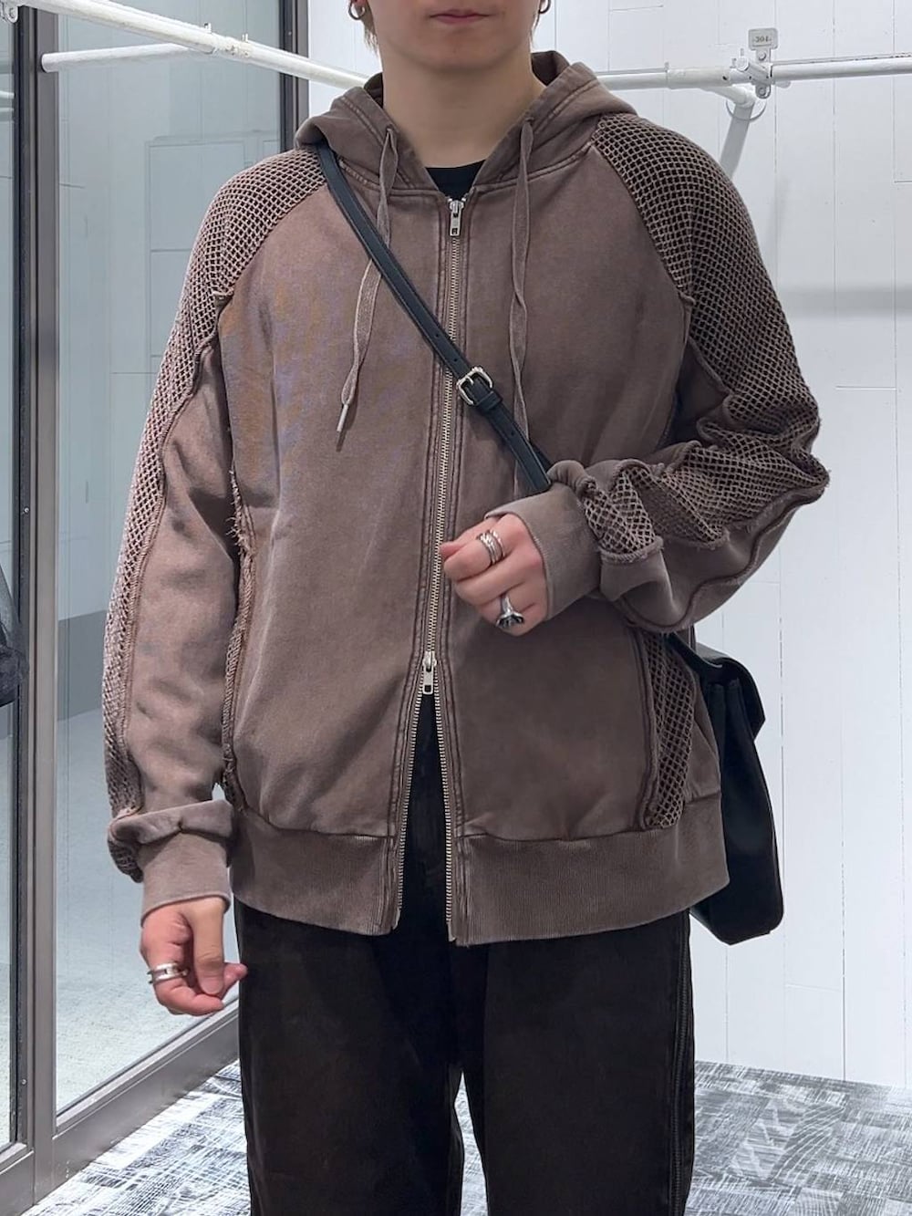 オレンジ系のデニムパンツ、ブラウン系のパーカー、ブラック系のドレスシューズを着用したメンズの春コーディネートの5枚目の写真