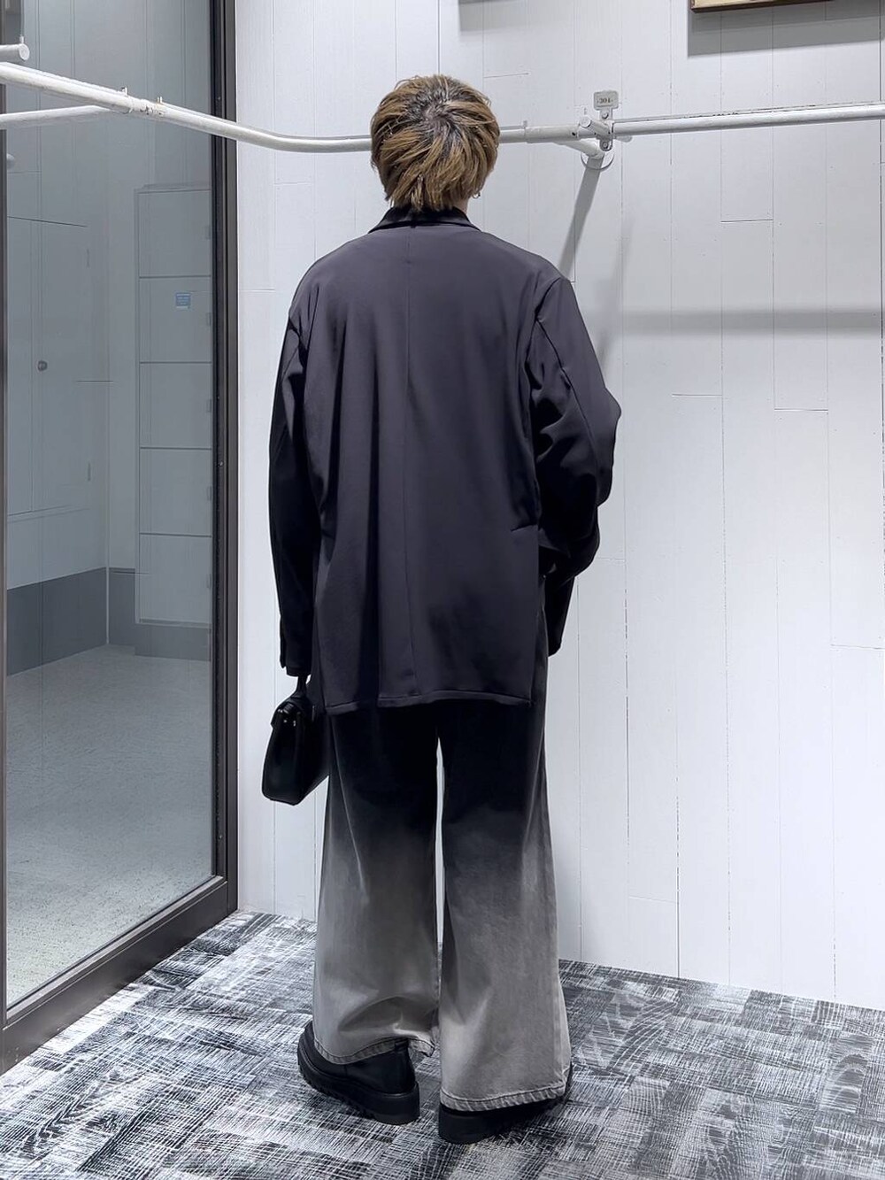 ブラック系のドレスシューズ、ブラック系のショルダーバッグ、ブラック系のテーラードジャケットを着用したメンズの春コーディネートの4枚目の写真