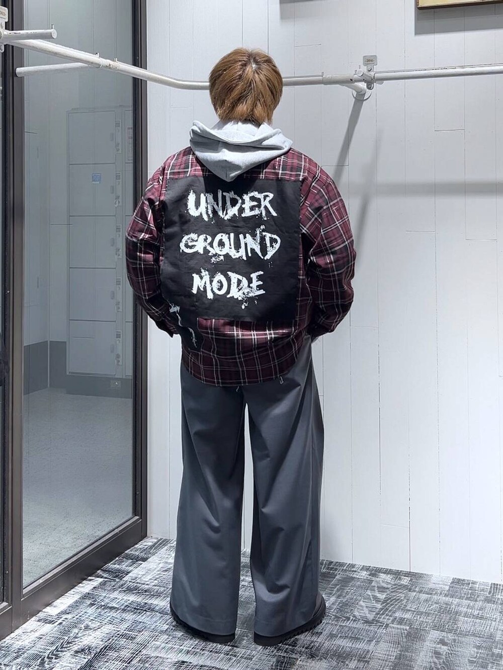 グレー系のパーカー、ブラック系のドレスシューズ、グレー系のスラックスを着用したメンズの春コーディネートの3枚目の写真