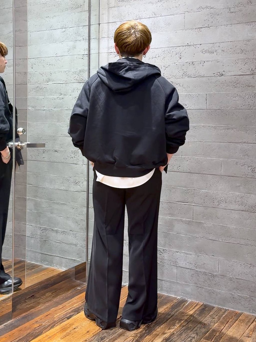 ブラック系のスラックス、ブラック系のスニーカー、ホワイト系のシャツ/ブラウスを着用したメンズの春コーディネートの3枚目の写真