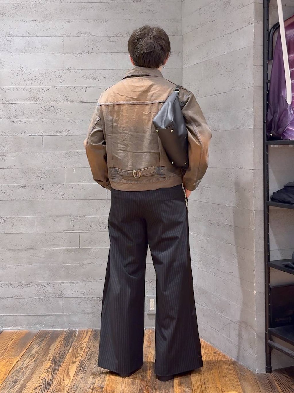 ブラウン系のデニムジャケット、ブラック系のスラックス、ブラック系のTシャツ/カットソーを着用したメンズの夏コーディネートの3枚目の写真