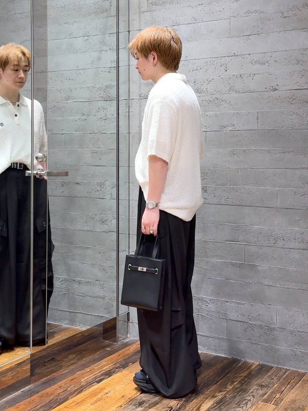 ブラック系のサンダル、ホワイト系のTシャツ/カットソー、ブラック系のカーゴパンツを着用したメンズの夏コーディネートの4枚目の写真