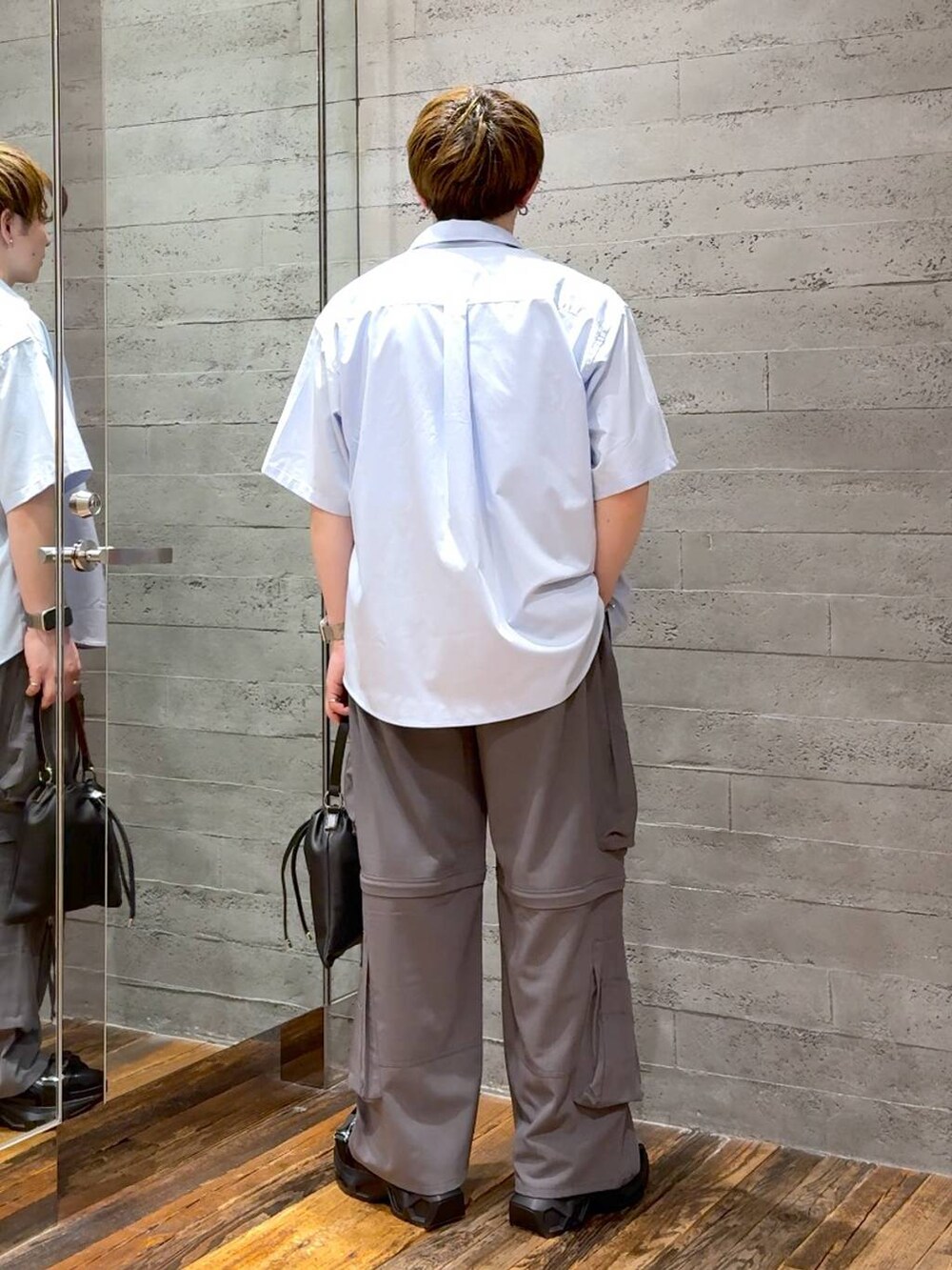 ブラック系のサンダル、ホワイト系のTシャツ/カットソー、グレー系のカーゴパンツを着用したメンズの春コーディネートの3枚目の写真