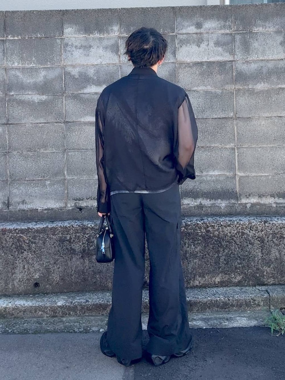 ブラック系のボストンバッグ、ブラック系のスニーカーを着用したメンズの秋コーディネートの3枚目の写真