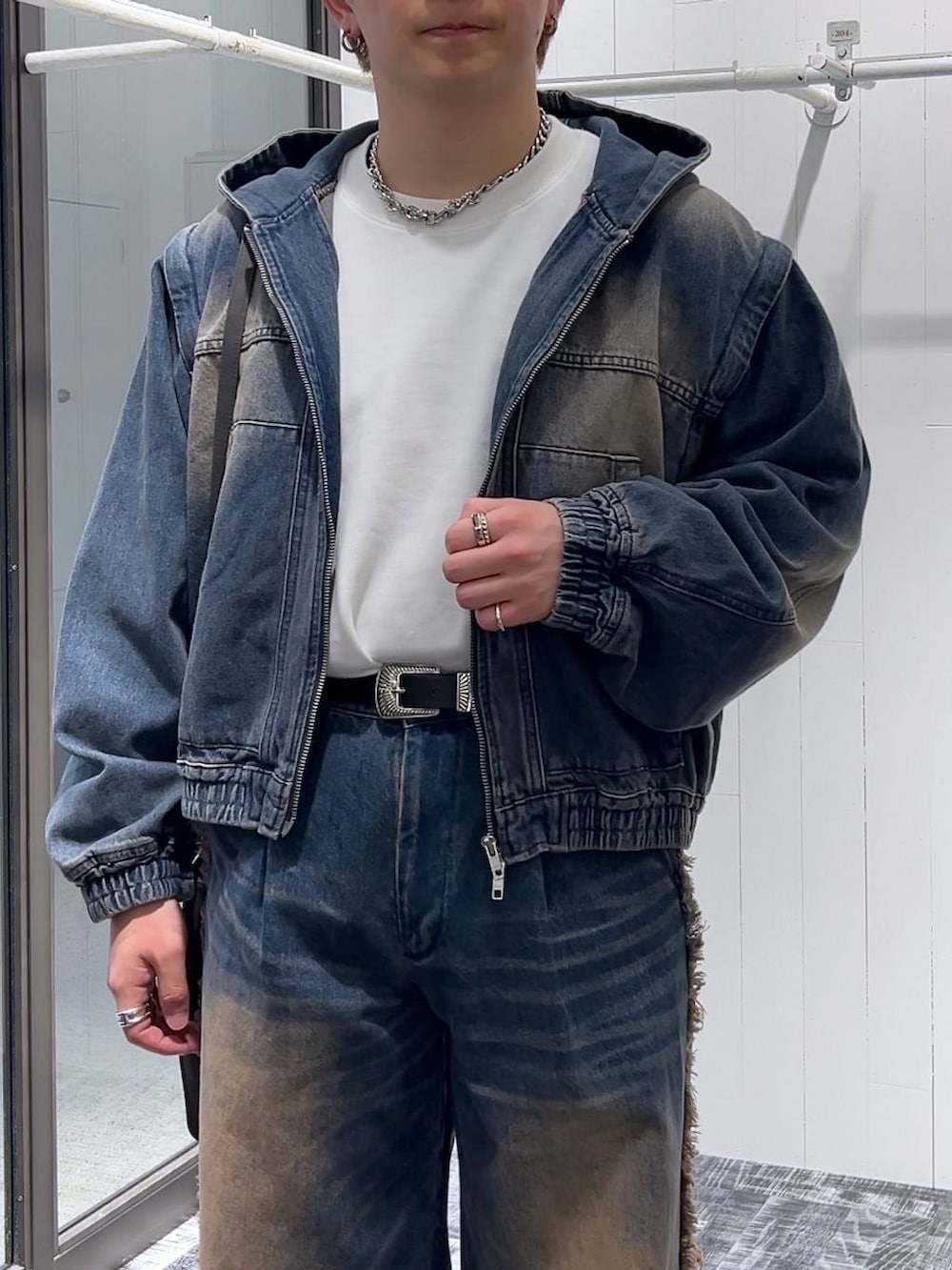 ブルー系のデニムパンツ、グレー系のショルダーバッグ、ホワイト系のTシャツ/カットソーを着用したメンズの冬コーディネートの5枚目の写真