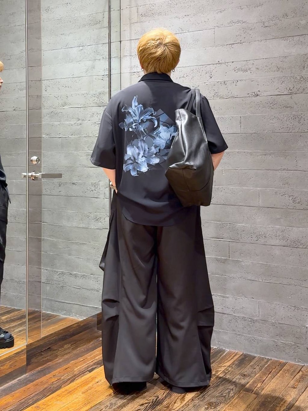 ブラック系のカーゴパンツ、ブラック系のトートバッグ、ブラック系のサンダルを着用したメンズの春コーディネートの3枚目の写真