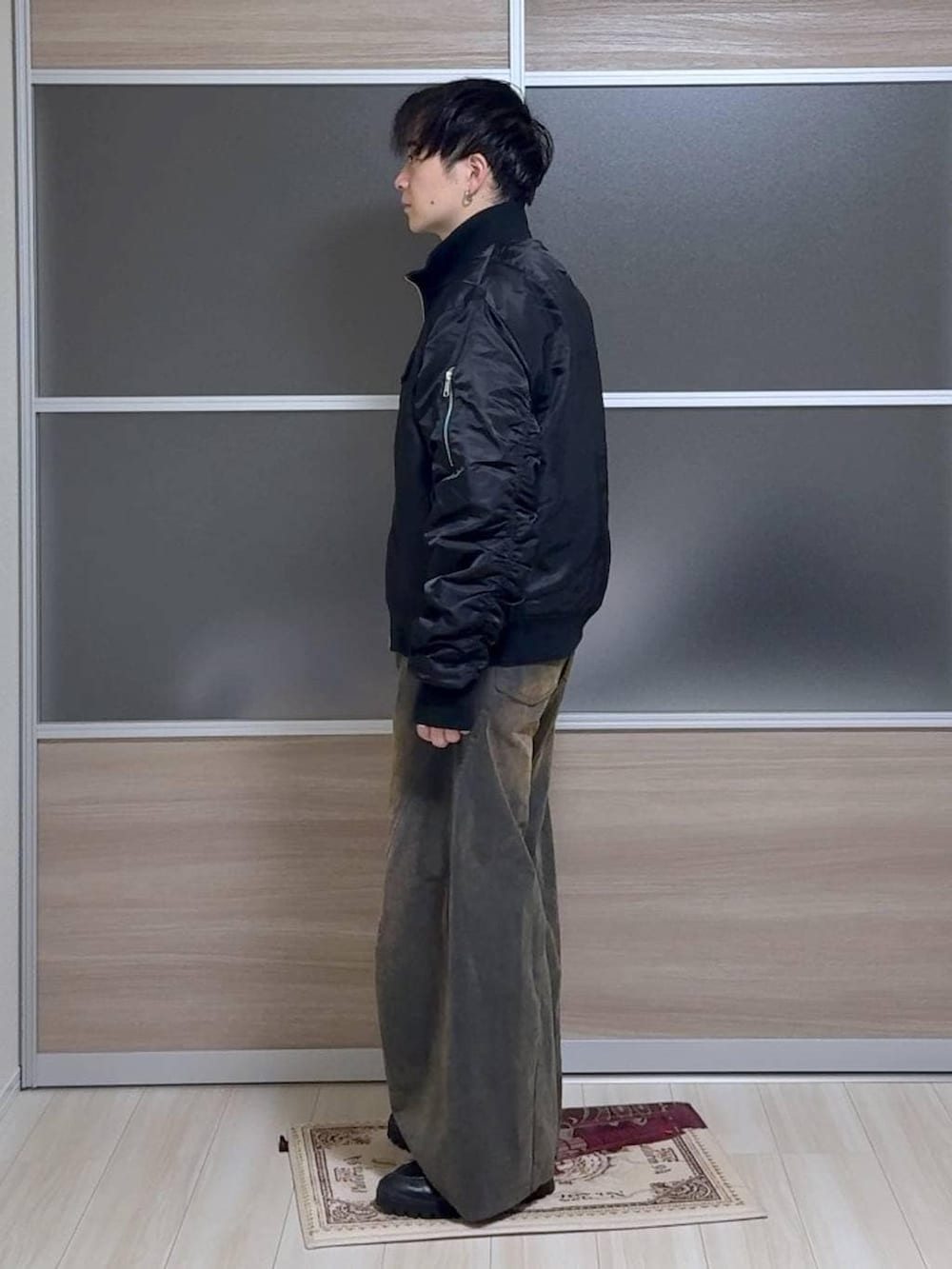 ブルー系のTシャツ/カットソー、グリーン系のデニムパンツ、シルバー系のピアス（片耳用）を着用したメンズの秋コーディネートの2枚目の写真