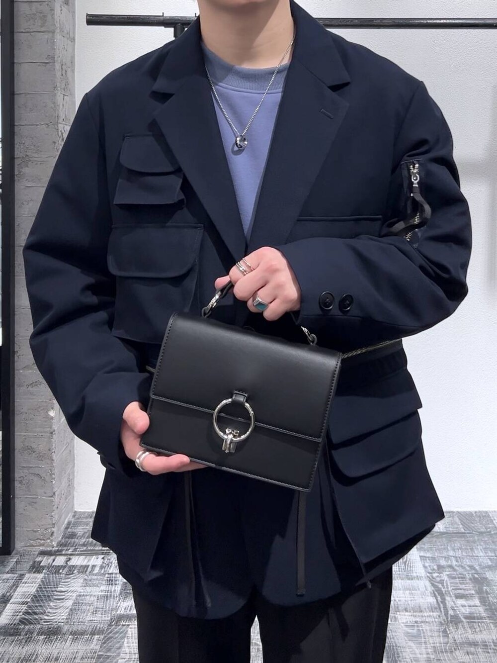 ブルー系のテーラードジャケット、ブラック系のスラックス、ブルー系のスウェットを着用したメンズの冬コーディネートの5枚目の写真