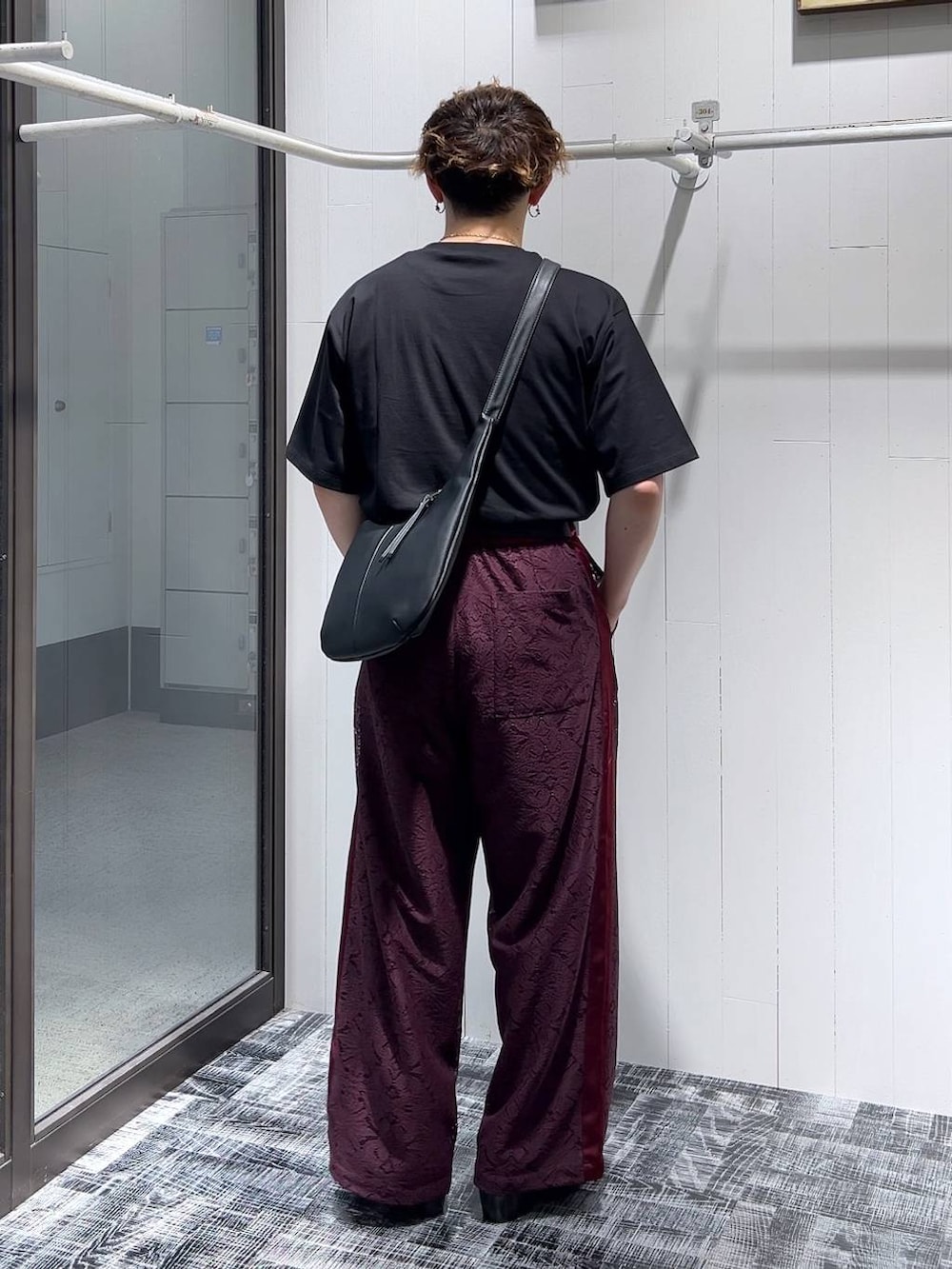 ブラック系のドレスシューズ、レッド系のその他パンツ、ブラック系のショルダーバッグを着用したメンズの夏コーディネートの3枚目の写真