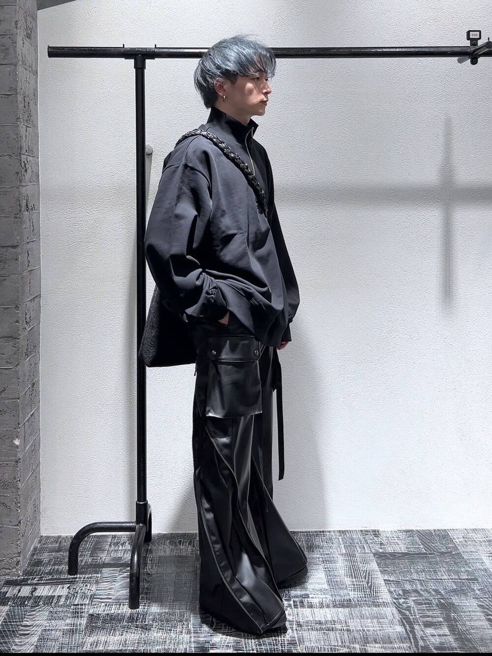 ブラック系のドレスシューズ、ブラック系のスウェット、ブラック系のショルダーバッグを着用したメンズの冬コーディネートの3枚目の写真