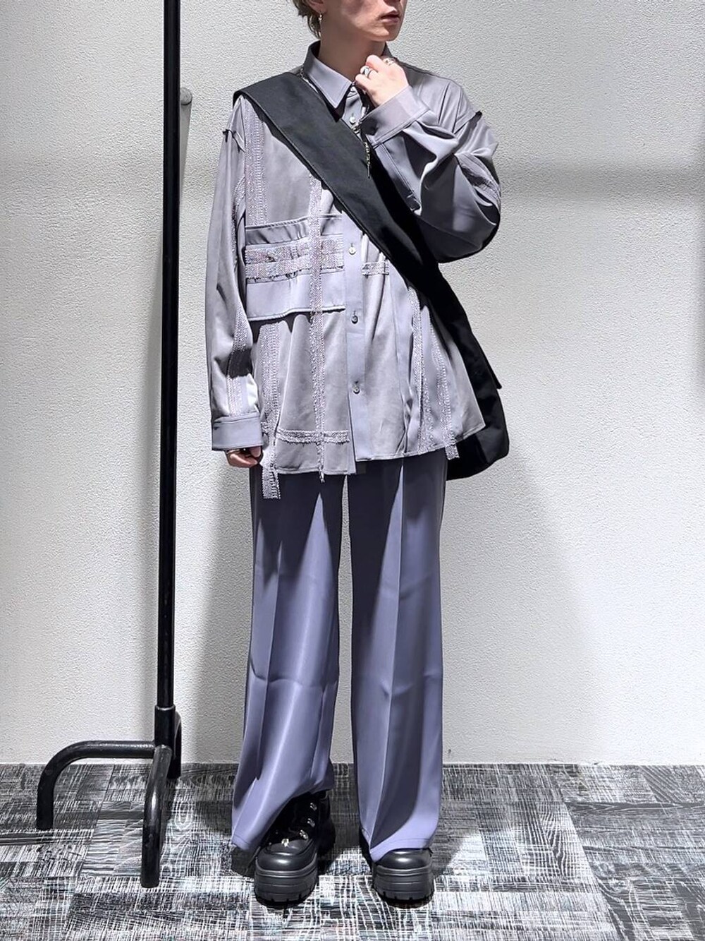 ブラック系のスニーカー、パープル系のスラックス、ブラック系のショルダーバッグを着用したメンズの春コーディネートの2枚目の写真