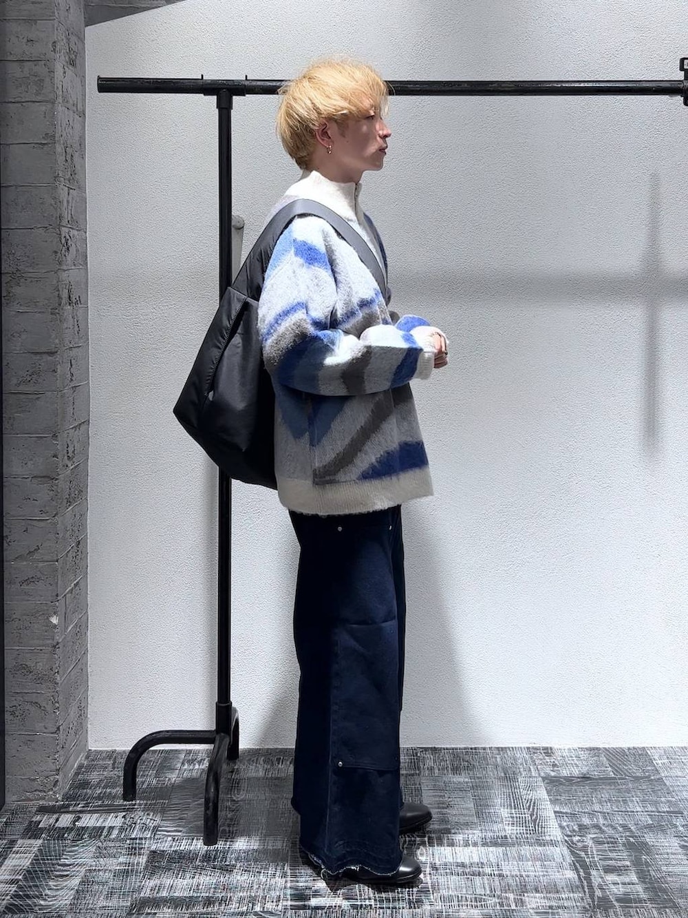 ブラック系のドレスシューズ、ブルー系のデニムパンツ、ホワイト系のニット/セーターを着用したメンズの秋コーディネートの3枚目の写真