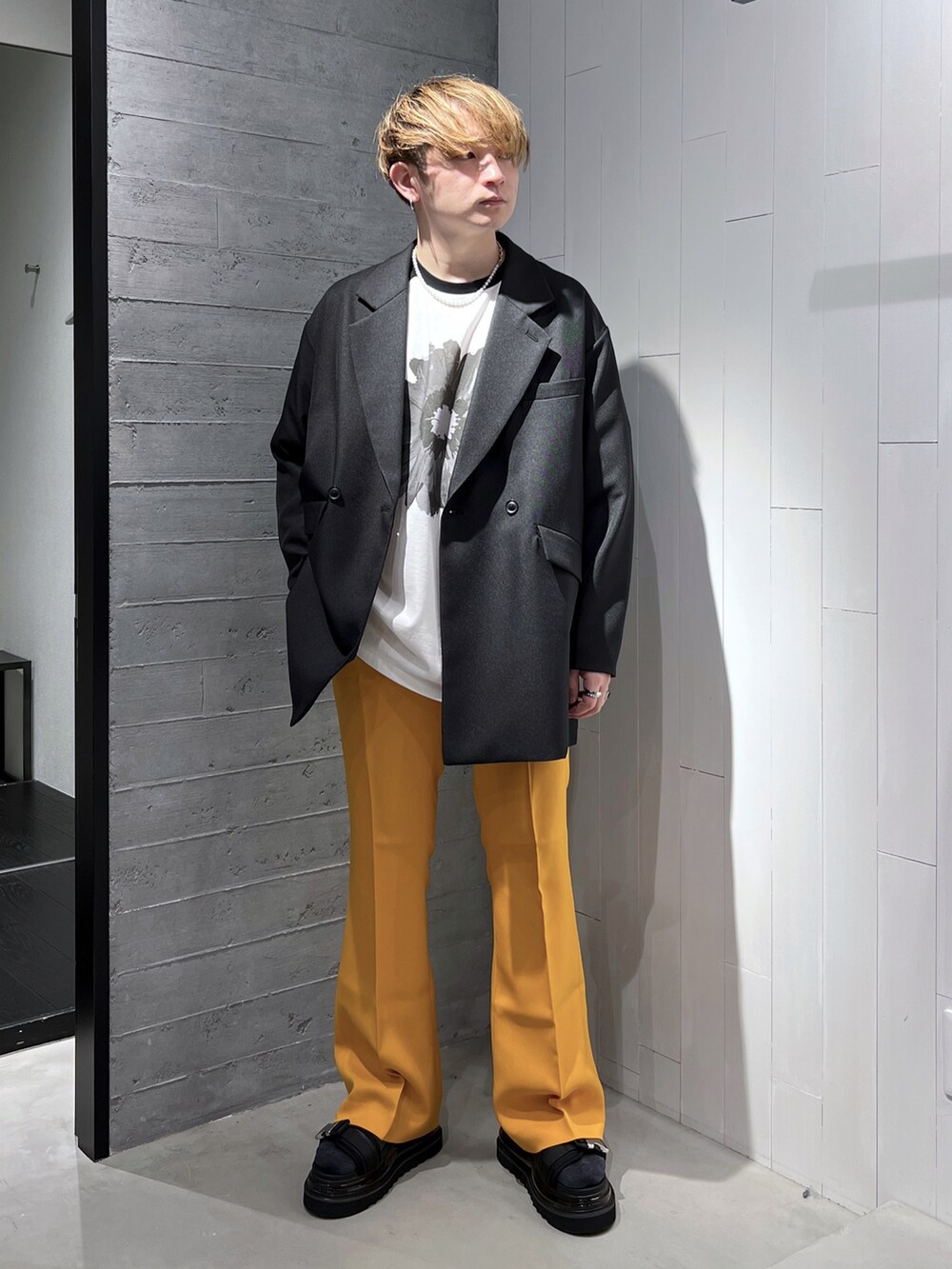 ブラック系のTシャツ/カットソー、ブラック系のテーラードジャケット、イエロー系のスラックスを着用したメンズの春コーディネートの2枚目の写真