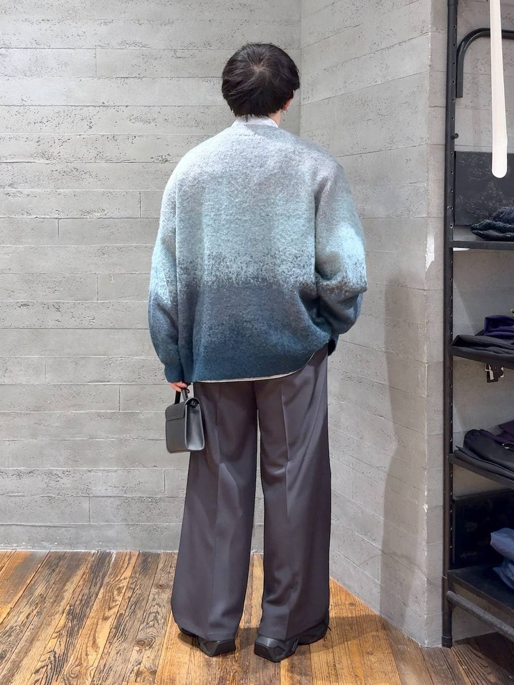 グリーン系のカーディガン/ボレロ、ブラック系のスニーカー、グレー系のスラックスを着用したメンズの冬コーディネートの3枚目の写真