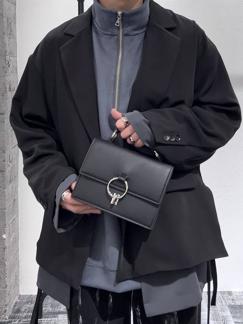 ブラック系のショルダーバッグ、グレー系のスウェット、ブラック系のブーツを着用したメンズの冬コーディネートの5枚目の写真