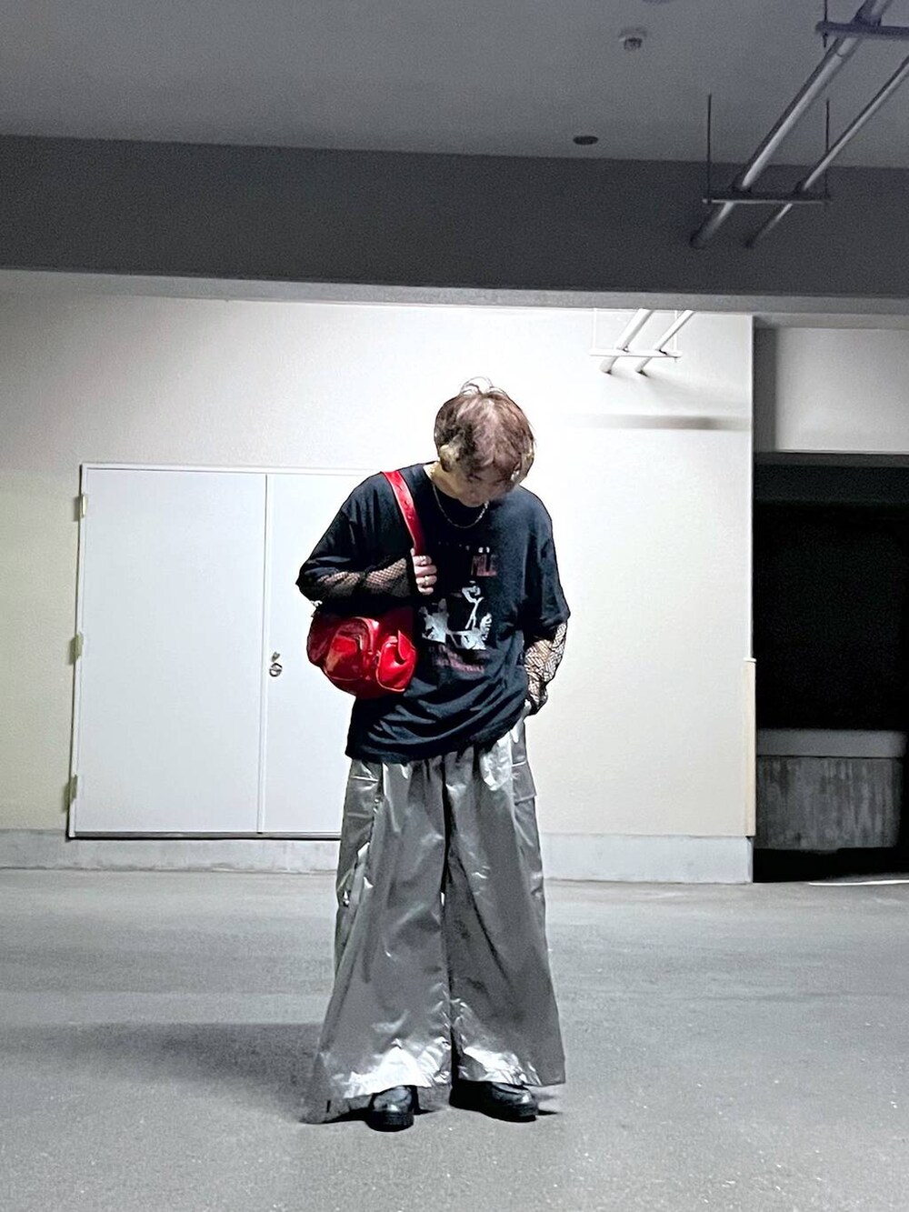 レッド系のショルダーバッグ、ブラック系のTシャツ/カットソー、シルバー系のカーゴパンツを着用したメンズの秋コーディネートの2枚目の写真