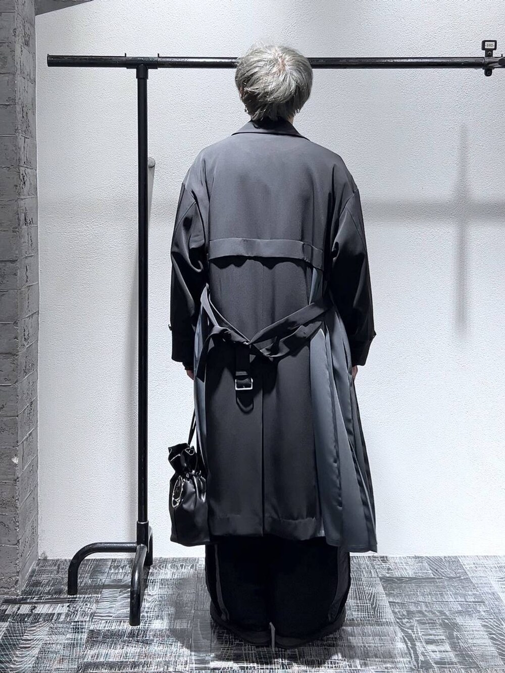 ブラック系のスウェット、ブラック系のステンカラーコート、ブラック系のドレスシューズを着用したメンズの冬コーディネートの4枚目の写真