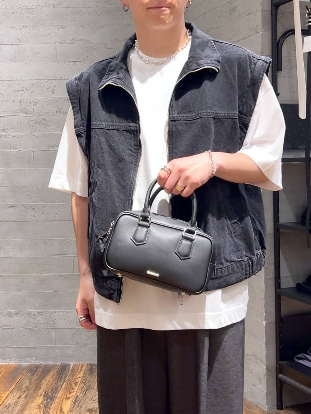 ブラック系のスラックス、ブラック系のローファー、ホワイト系のTシャツ/カットソーを着用したメンズの夏コーディネートの5枚目の写真