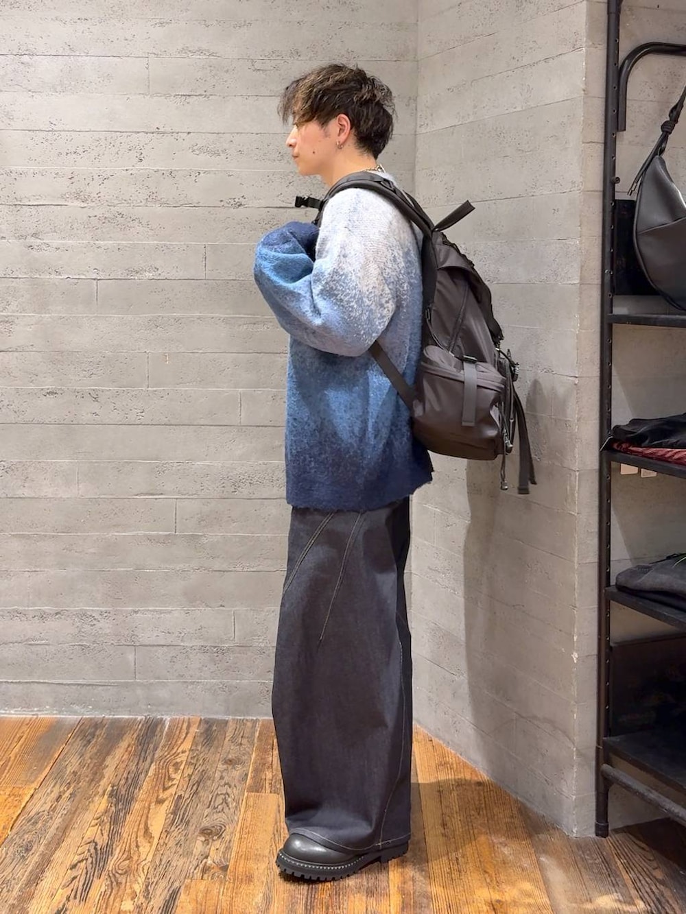 ブルー系のデニムパンツ、ブルー系のカーディガン/ボレロ、ブラック系のバックパック/リュックを着用したメンズの秋コーディネートの4枚目の写真
