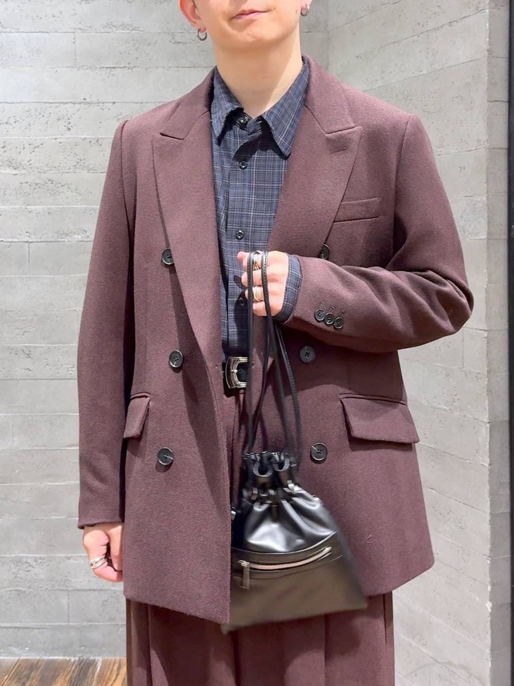 ブラック系のスニーカー、ブラック系のショルダーバッグ、レッド系のスラックスを着用したメンズの秋コーディネートの5枚目の写真