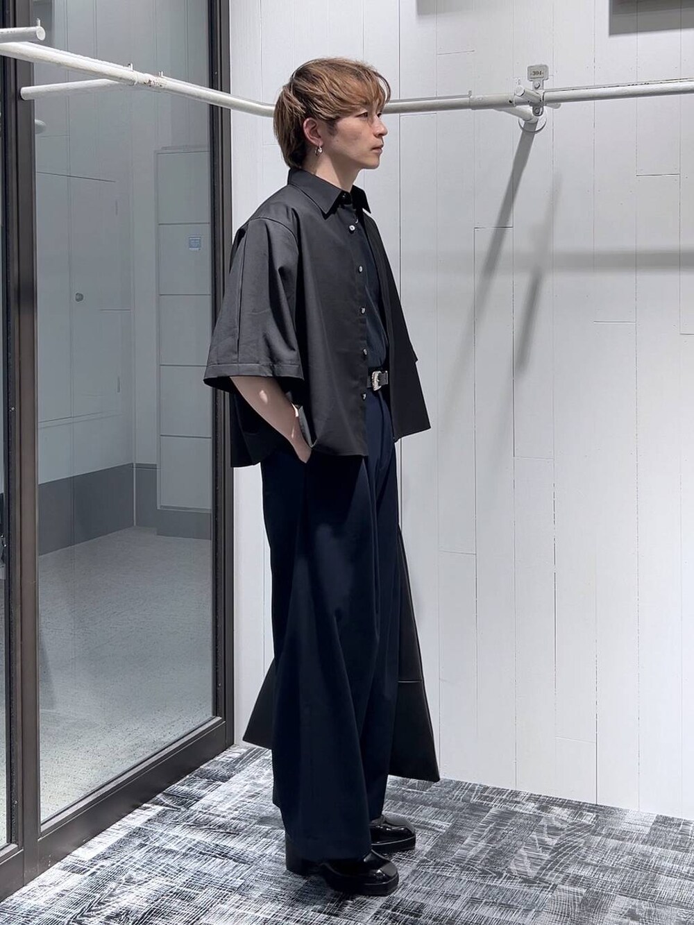 ブラック系のドレスシューズ、ブラック系のトートバッグ、ブラック系のTシャツ/カットソーを着用したメンズの春コーディネートの3枚目の写真