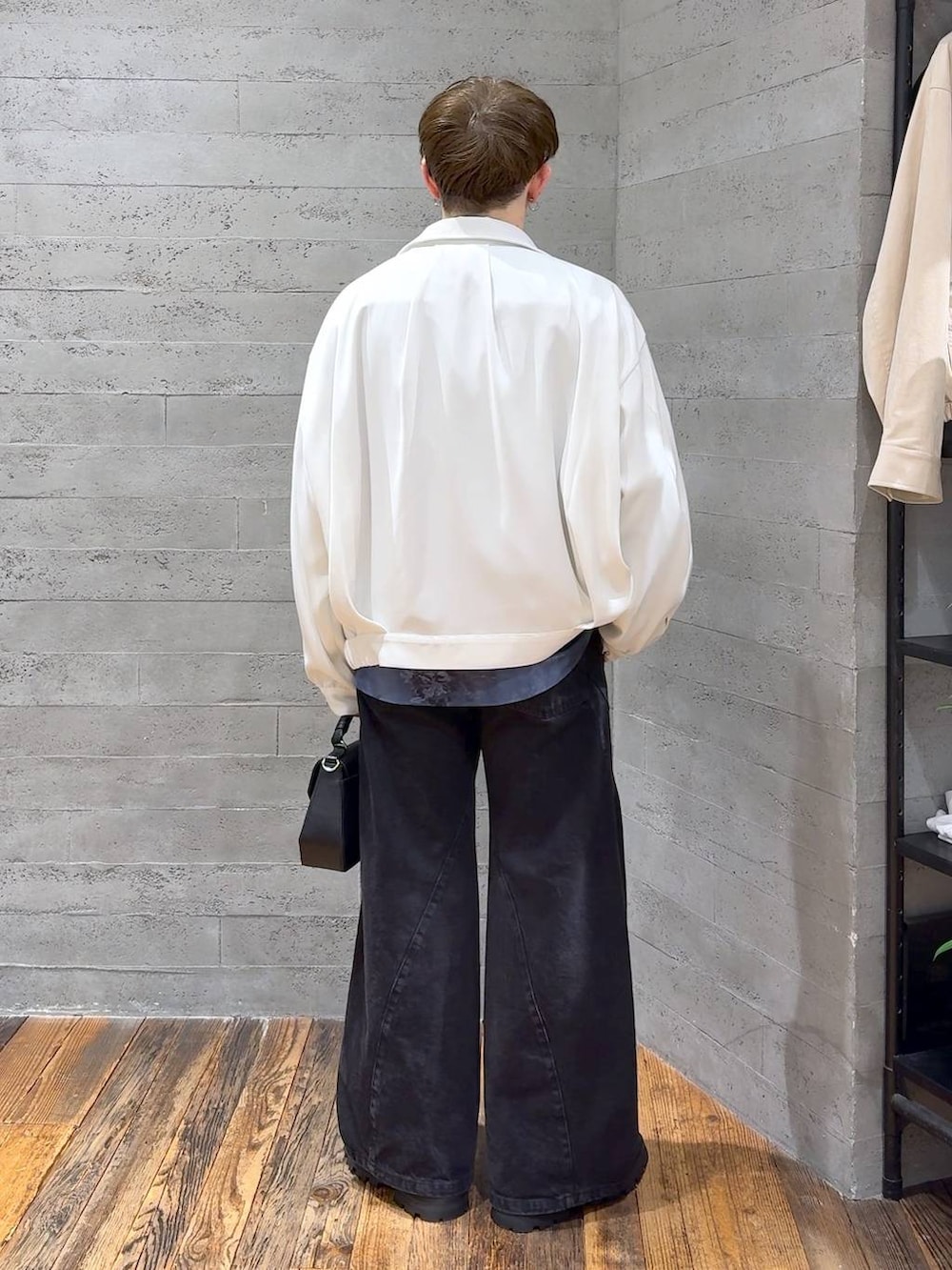 ブラック系のドレスシューズ、ブラック系のデニムパンツ、ホワイト系のブルゾンを着用したメンズの春コーディネートの3枚目の写真