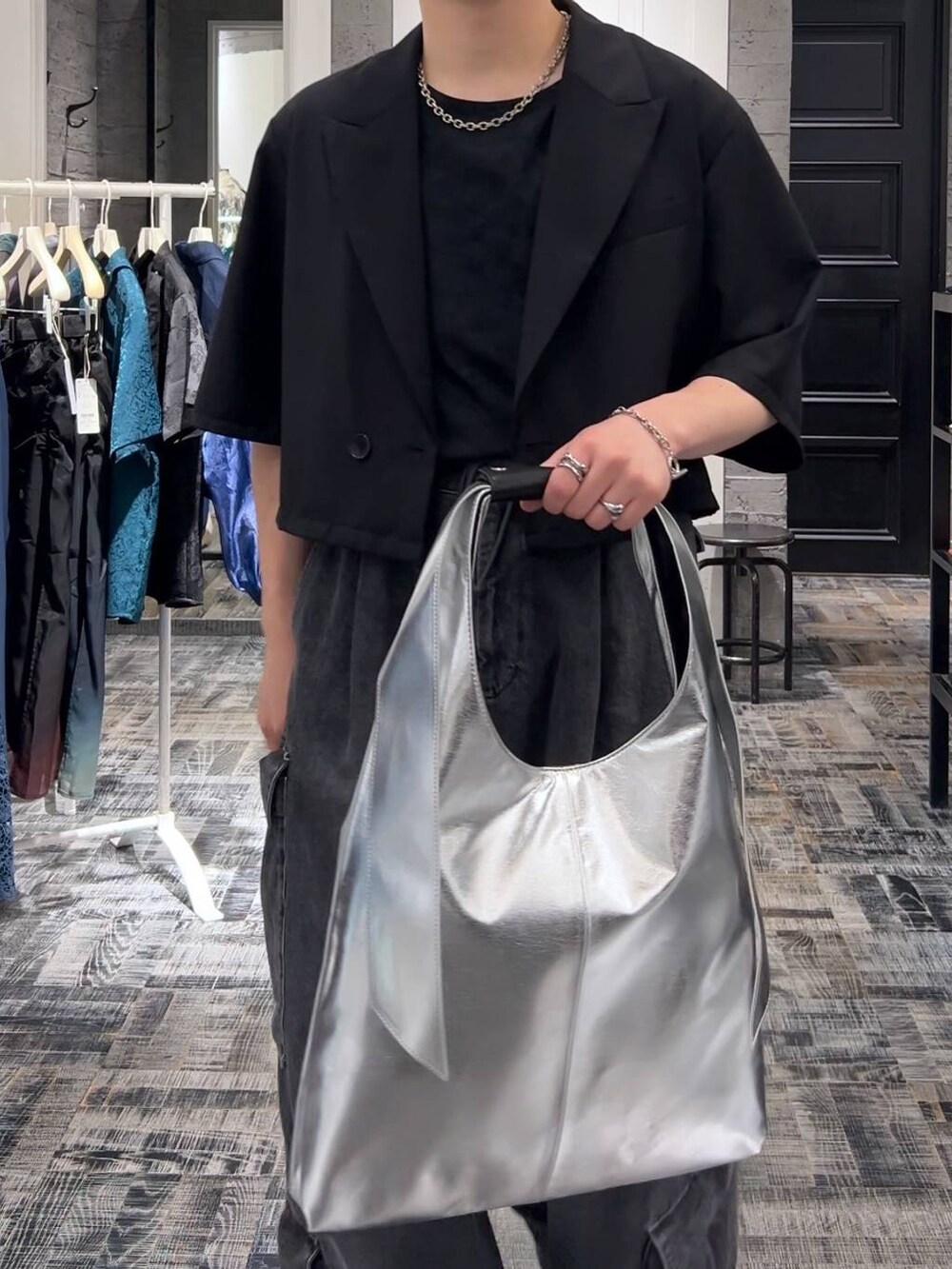 シルバー系のトートバッグ、グレー系のTシャツ/カットソー、ブラック系のサンダルを着用したメンズの夏コーディネートの4枚目の写真