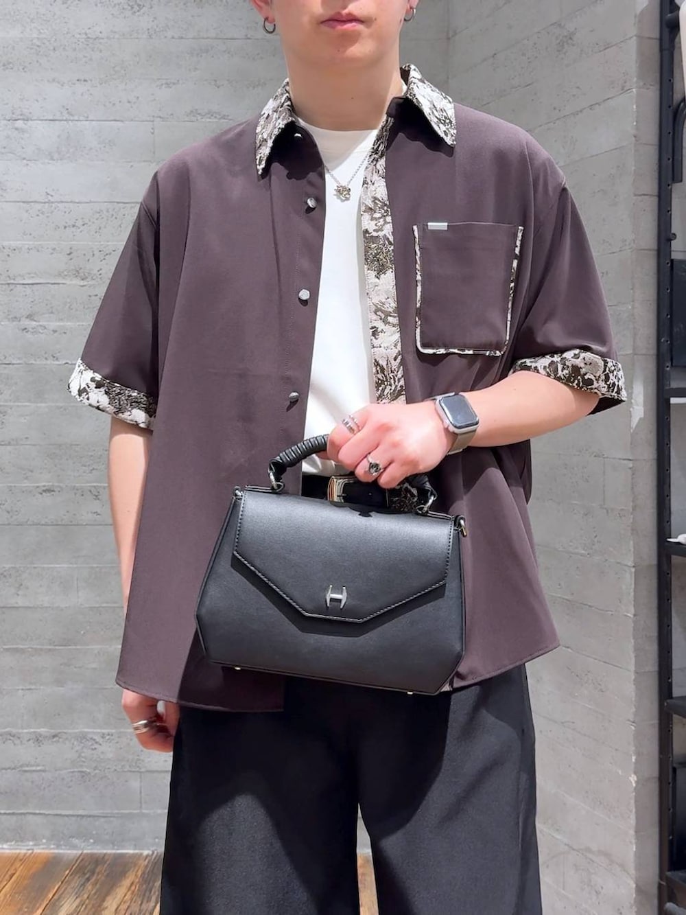 ブラック系のサンダル、ホワイト系のTシャツ/カットソー、ブラック系のスラックスを着用したメンズの春コーディネートの5枚目の写真