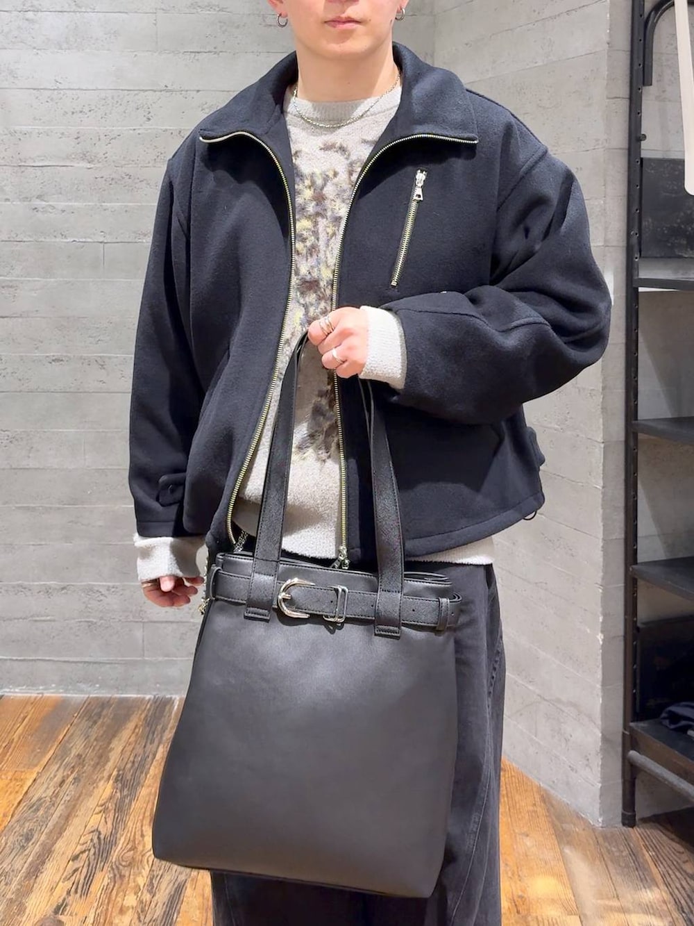 ブラック系のデニムパンツ、ブラック系のブルゾン、ブラック系のトートバッグを着用したメンズの秋コーディネートの5枚目の写真