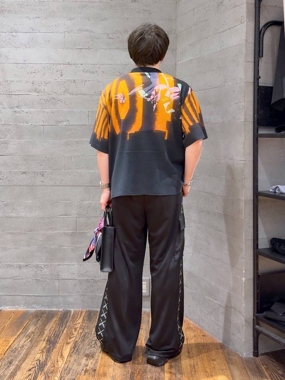 ブラック系のカーゴパンツ、ブラック系のニット/セーター、ブラック系のサンダルを着用したメンズの夏コーディネートの3枚目の写真