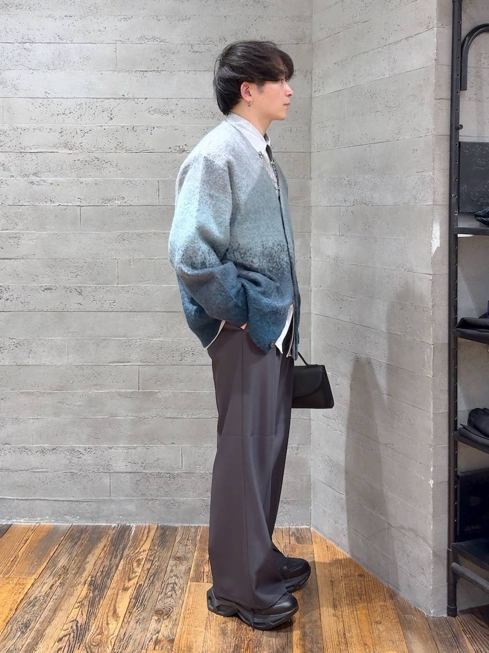 グリーン系のカーディガン/ボレロ、ブラック系のスニーカー、グレー系のスラックスを着用したメンズの冬コーディネートの2枚目の写真