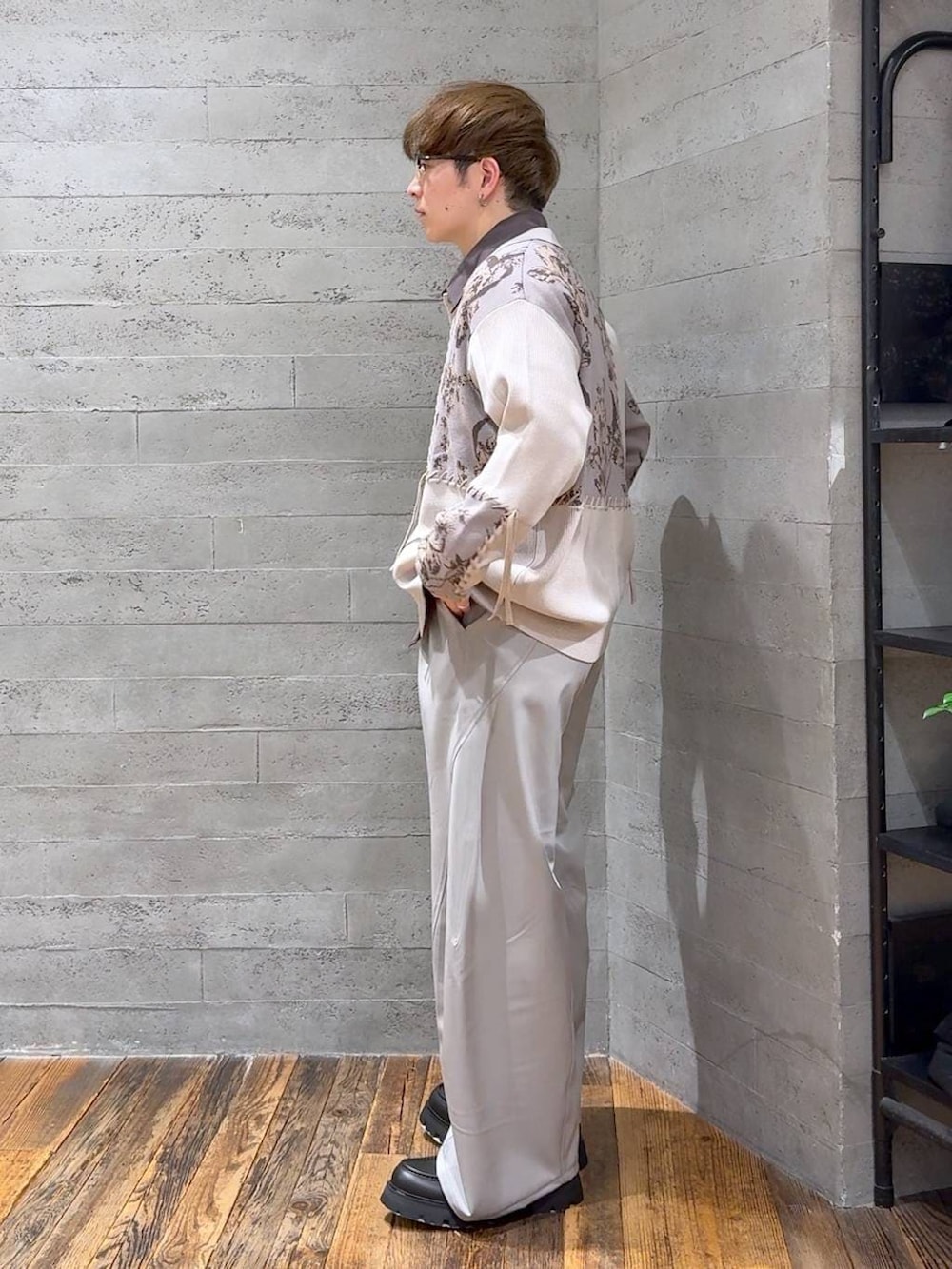 ブラック系のドレスシューズ、グレー系のスラックス、グレー系のニット/セーターを着用したメンズの春コーディネートの4枚目の写真