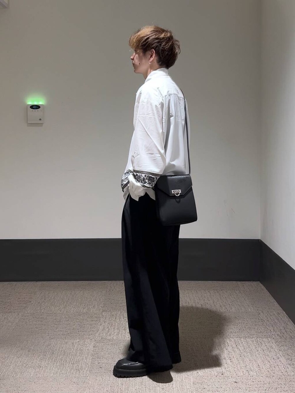 ブラック系のドレスシューズ、ブラック系のショルダーバッグ、ブラック系のスラックスを着用したメンズの夏コーディネートの3枚目の写真