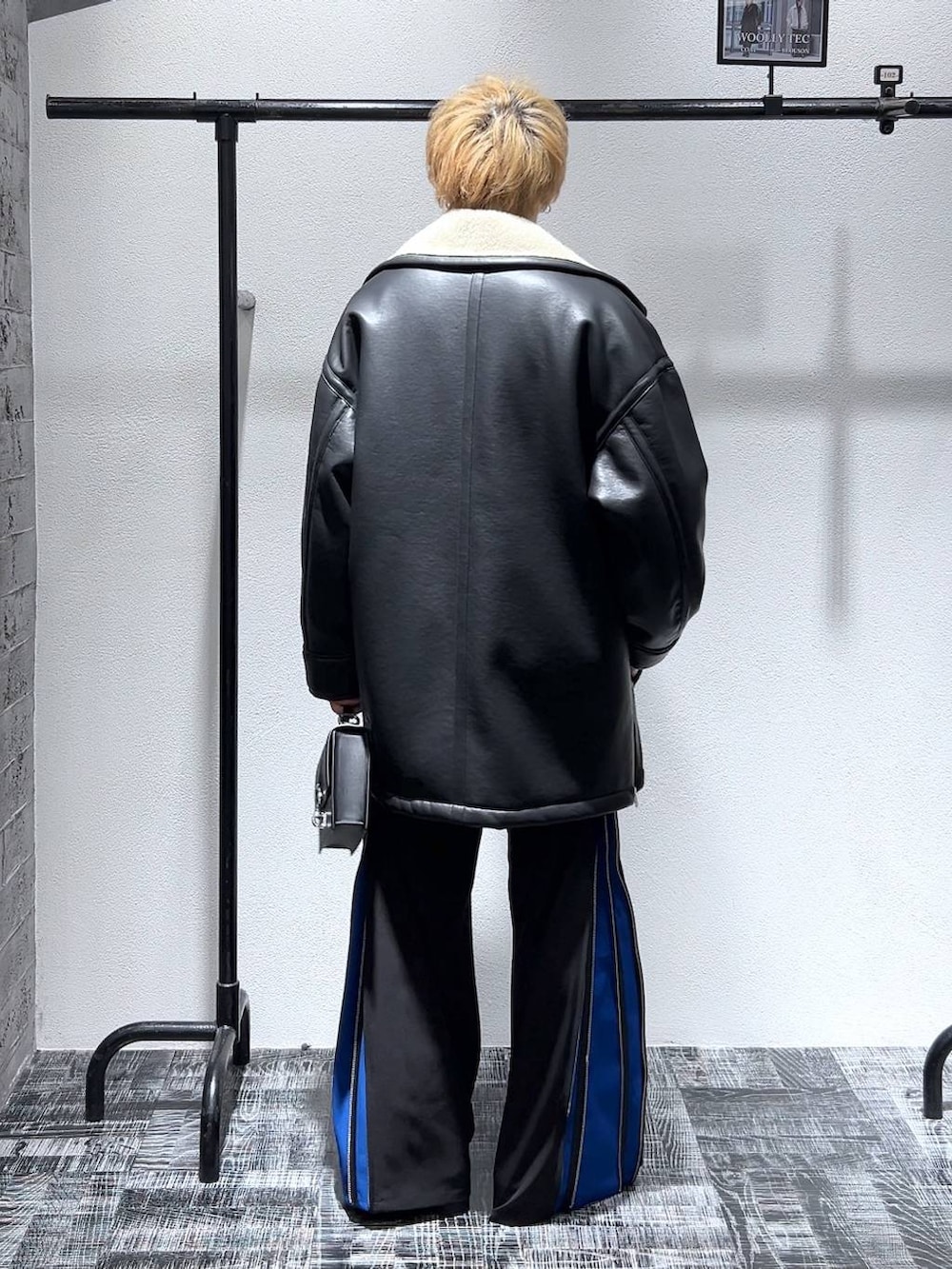 グレー系のスウェット、ブラック系のショルダーバッグ、ブラック系のブーツを着用したメンズの冬コーディネートの4枚目の写真