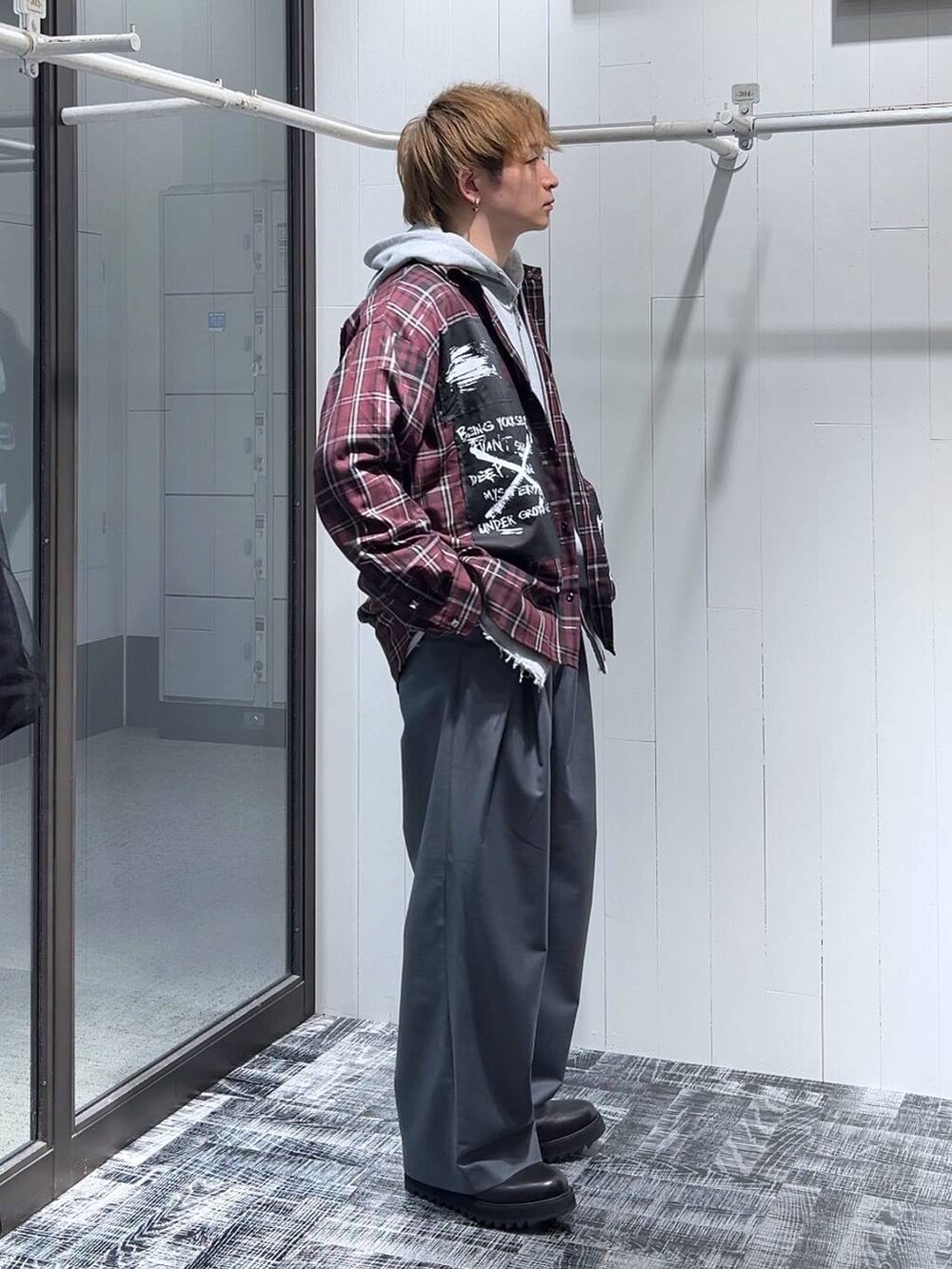 グレー系のパーカー、ブラック系のドレスシューズ、グレー系のスラックスを着用したメンズの春コーディネートの2枚目の写真