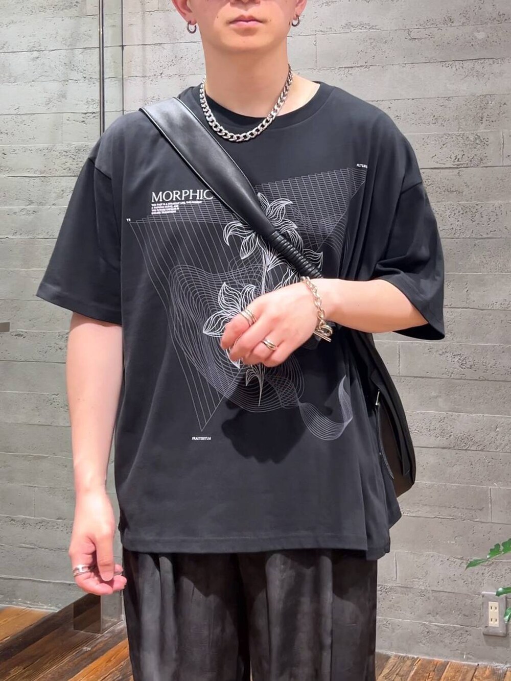 ブラック系のサンダル、グレー系のスラックス、ブラック系のTシャツ/カットソーを着用したメンズの夏コーディネートの5枚目の写真